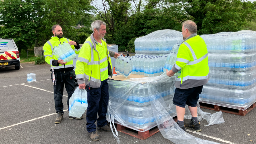 Image shows bottled water being handed out