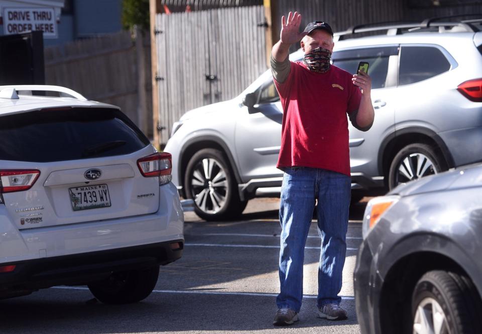 Gary Leech, owner of Congdon's Family Restaurant waves to seniors as they pass through the drive-thru Thanksgiving dinner event on Wednesday at his Wells eatery. 