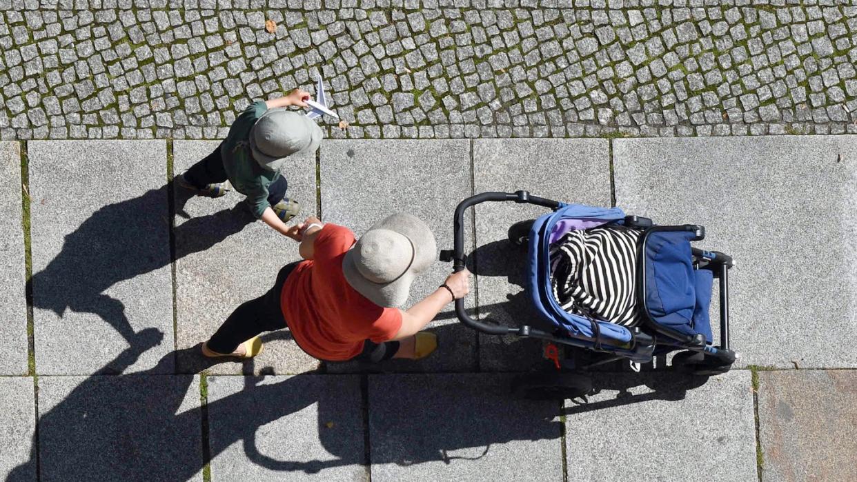 Eine Frau und ein Kind auf einem Gehweg. Der BGH hat zum Thema verbotene Leihmutterschaft geurteilt. Foto: Jens Kalaene/dpa-Zentralbild