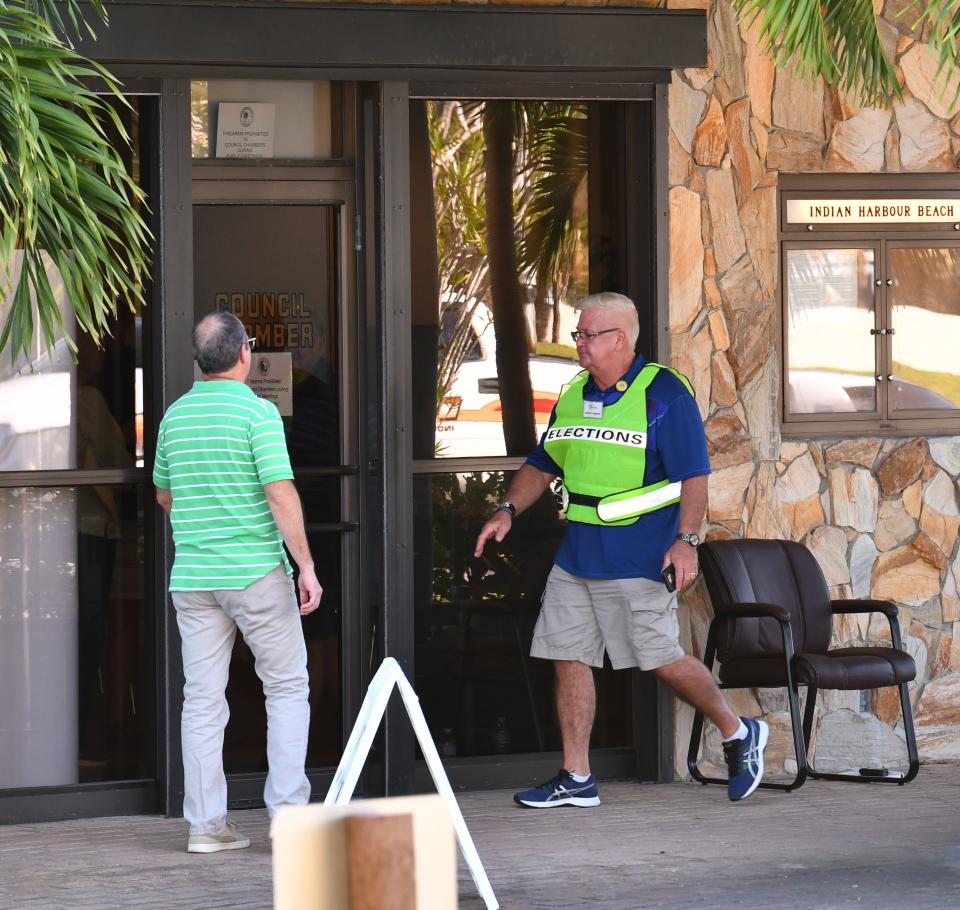 A poll worker opens the door for a man voting in a previous election at Indian Harbour Beach City Hall. There are two seats on the Indian Harbour Beach City Council on the ballot this year.