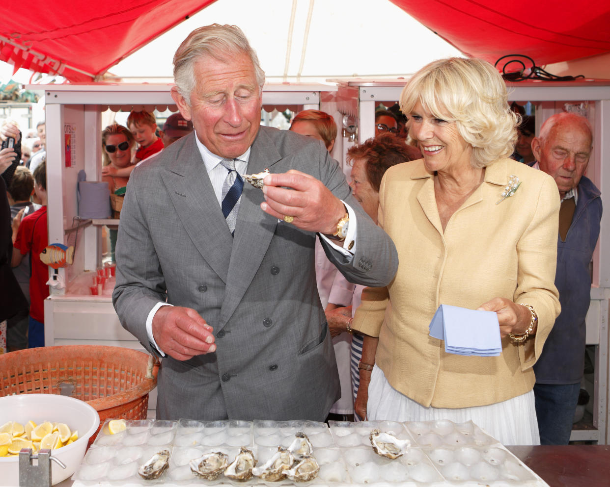 WHITSTABLE, UNITED KINGDOM - JULY 29: (EMBARGOED FOR PUBLICATION IN UK NEWSPAPERS UNTIL 48 HOURS AFTER CREATE DATE AND TIME) Prince Charles, Prince of Wales eats an oyster as Camilla, Duchess of Cornwall looks on during their visit to the Whitstable Oyster Festival on July 29, 2013 in Whitstable, England. (Photo by Max Mumby/Indigo/Getty Images)