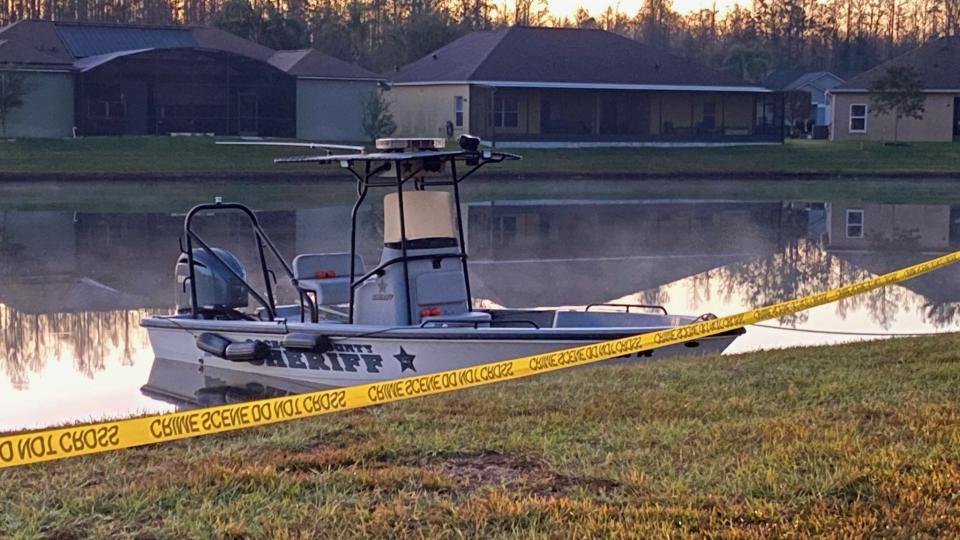 Osceola County deputies gather at a pond off of Bridgewater Court in Kissimmee early Wednesday.