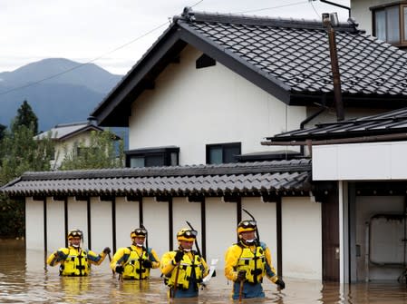 Rescue workers search a flooded area in the aftermath of Typhoon Hagibis, which caused severe floods at the Chikuma River in Nagano