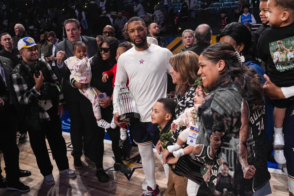 Milwaukee Bucks guard Damian Lillard (0) is surrounded by family after receiving the MVP trophy after the East defeated the West 211-186 in the NBA All-Star basketball game in Indianapolis, Sunday, Feb. 18, 2024. (AP Photo/Darron Cummings)