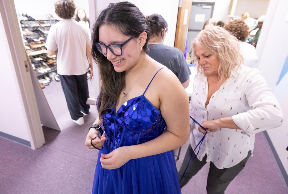 Washington High School junior Lizzy Mora is fitted for a prom dress with the help of volunteer Susan Linz at the Bear Hugs prom pop-up shop. For the past three weeks students from more than 16 school districts in Stark, Summit, Tuscarawas and Carroll counties have visited the shop for a personalized shopping experience.