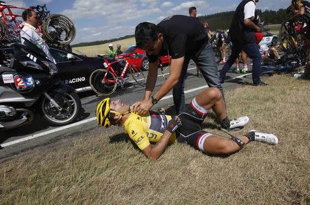 Race leader and yellow jersey holder Trek Factory rider Fabian Cancellara of Switzerland receives assistance as he lies on the ground after a fall during the 159,5 km (99 miles) third stage of the 102nd Tour de France cycling race from Anvers to Huy, Belgium, July 6, 2015. REUTERS/Eric Gaillard