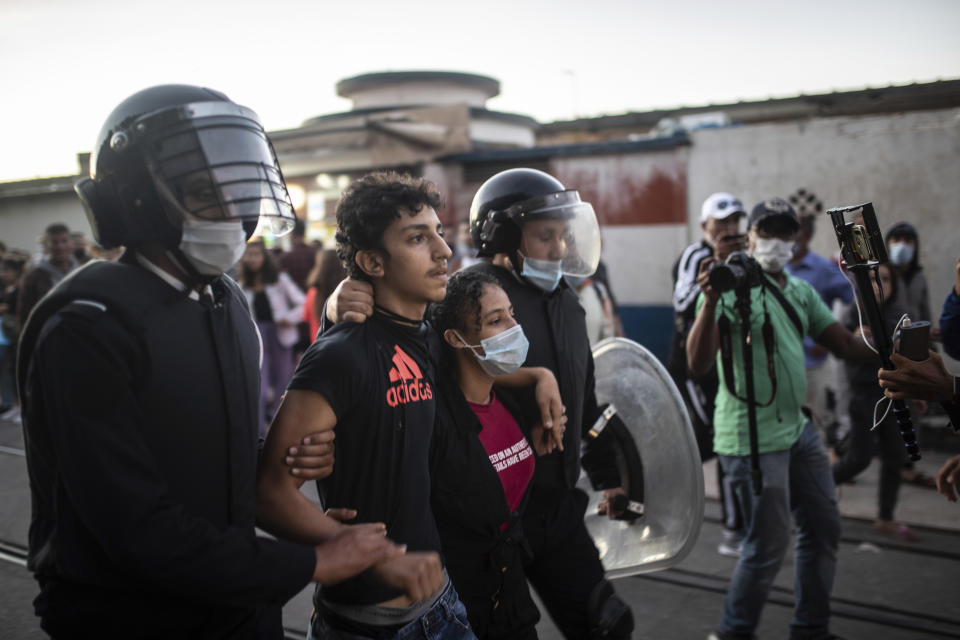 Security forces detain protesters during a demonstration against the government enforcing of a mandatory COVID-19 vaccine pass, in Rabat, Morocco, Sunday, Oct. 31, 2021. (AP Photo/Mosa'ab Elshamy)