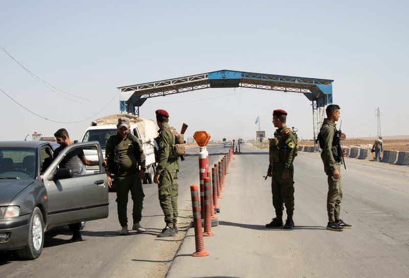 Members of the Kurdish internal security force man a checkpoint in Qamishli