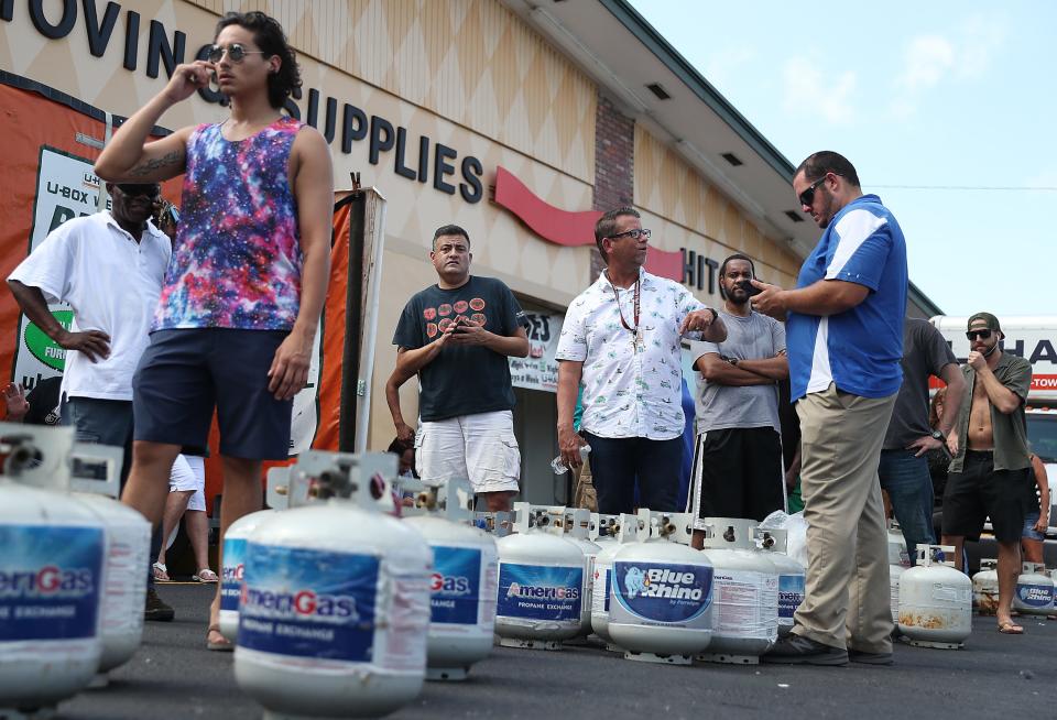 People wait in line at a U-Haul store to fill their propane tanks before the possible arrival of Hurricane Dorian on August 30, 2019 in Boynton Beach, Fla.