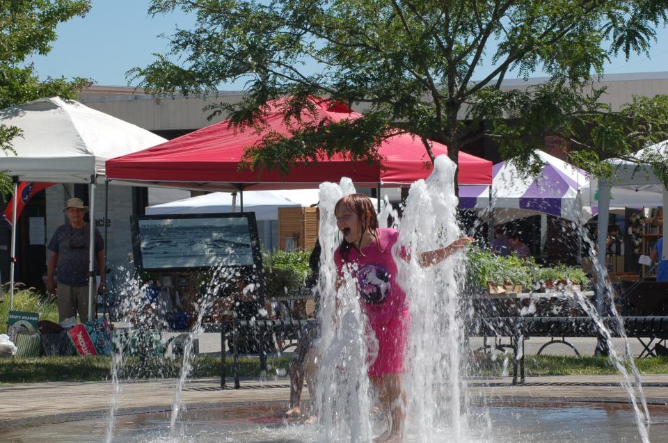 A girl plays in the Historic Jackson Square fountain at the 2022 Lavender Festival.