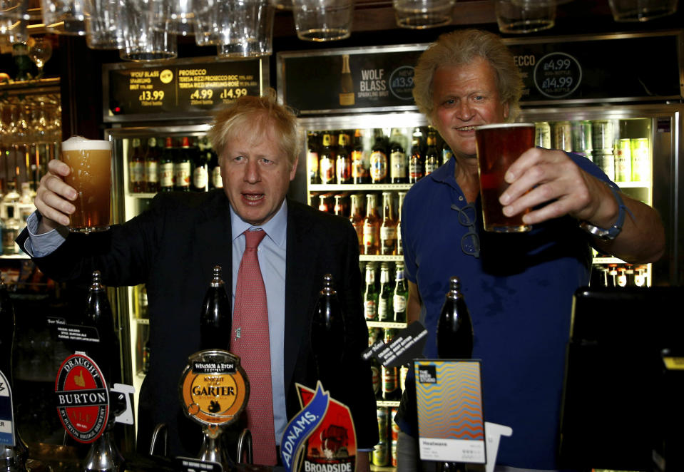 Conservative Party leadership candidate Boris Johnson gestures with Tim Martin, Chairman of JD Wetherspoon,  during a visit to Wetherspoons Metropolitan Bar in London, Wednesday July 10, 2019. (Henry Nicholls/Pool Photo via AP)
