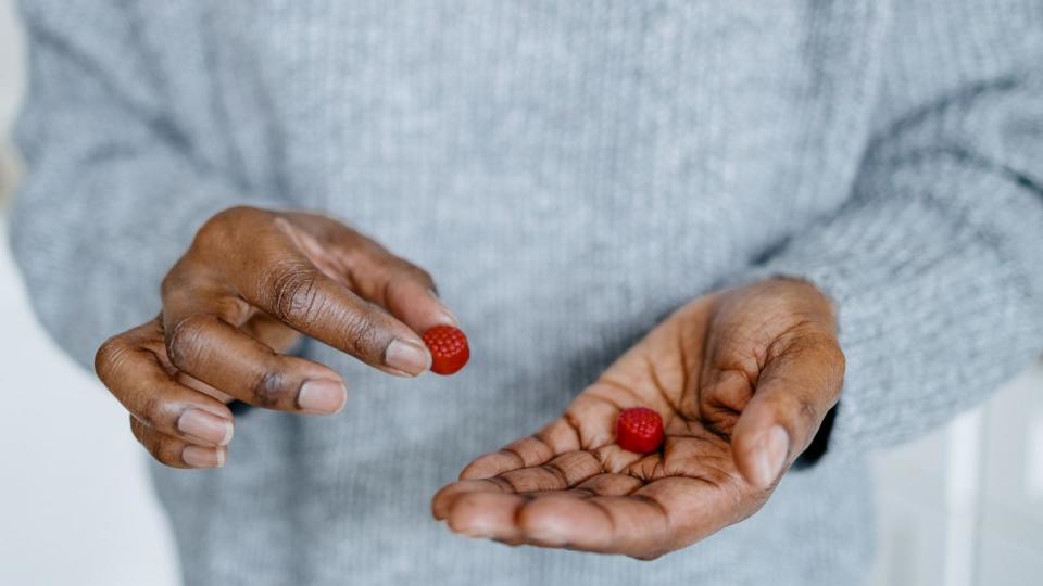 PHOTO: Woman Holds Fruit-Flavored Gummies (Grace Cary/Getty Images)