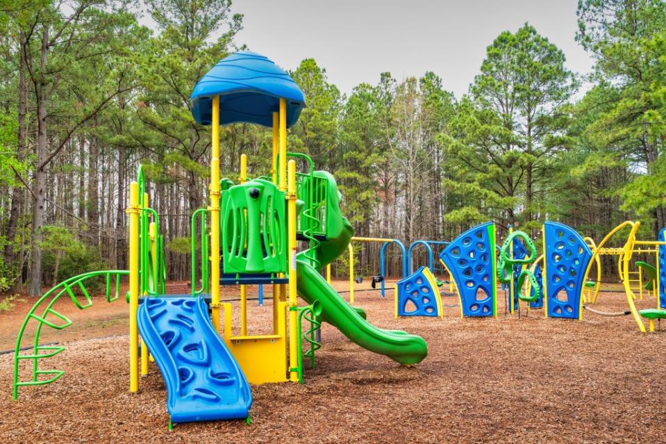 Playground with colorful slide and wood chips in Oak Grove Lake Park, Chesapeake via Getty Images