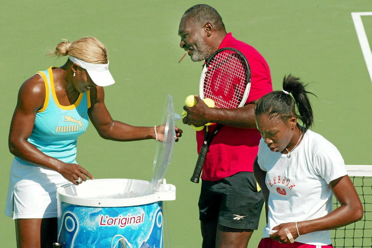 Serena Williams, Venus Williams et leur père Richard Williams durant un entraînement pendant l'US Open 2002.  - Credit:TIMOTHY A. CLARY / AFP