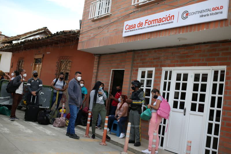 People line up in front of the formation house of the Zijin mine in Buritica