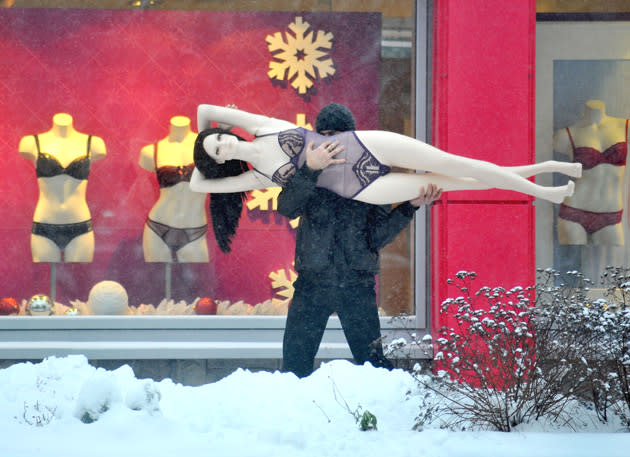 A man carries a mannequin in the Belarus capital Minsk, on December 10, 2012. AFP PHOTO / VIKTOR DRACHEV