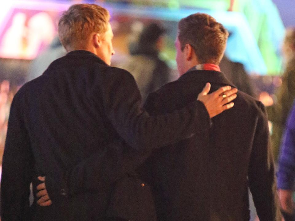 Dustin Lance Black and Tom Daley walking away from camera with backs facing us