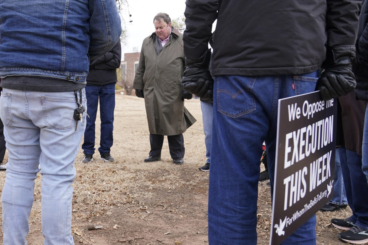 The Rev. Don Heath, center, says a prayer following a protest on the street outside the Governor's mansion, Thursday, Jan. 12, 2023, in Oklahoma City, after Oklahoma executed a Scott James Eizember, 62, who was convicted of killing an elderly couple and committing other crimes 20 years ago before authorities caught up to him in Texas after a manhunt. (AP Photo/Sue Ogrocki)