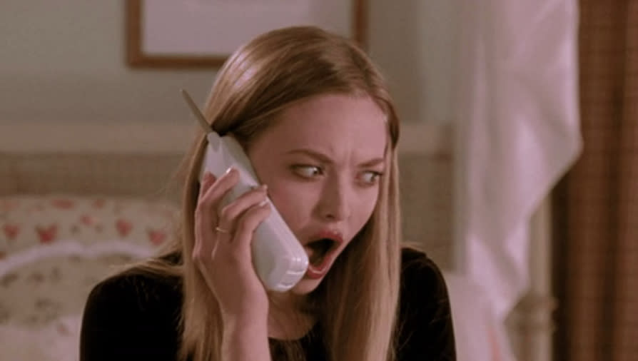 Amanda Seyfried in a surprised expression while talking on a cordless phone