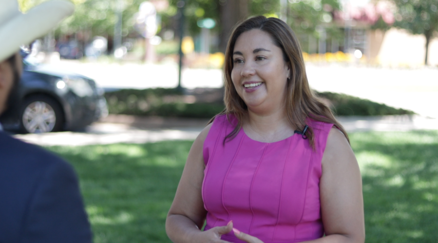 Yadira Caraveo smiles as she sits for an interview in a shaded park