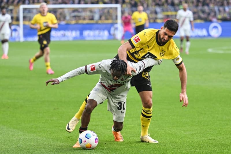 Leverkusen's Jeremie Frimpong and Dortmund's Emre Can battle for the ball during the German Bundesliga soccer match between Borussia Dortmund and Bayer Leverkusen at Signal Iduna Park. Bernd Thissen/dpa