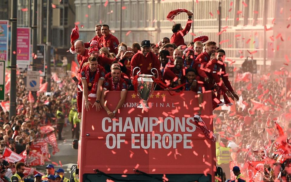 Liverpool's German manager Jurgen Klopp (C) holds the trophy during an open-top bus parade around Liverpool, north-west England on June 2, 2019, after winning the UEFA Champions League final football match between Liverpool and Tottenham. Klopp surprised the football world by announcing on January 26, 2024 that he would leave Liverpool at the end of the season