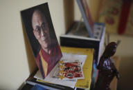 A photo of the Dalai Lama sits next to a football trading card on a bookshelf in Jalue Dorje's bedroom in Columbia Heights, Minn., on Monday, July 19, 2021. When he was an infant, Jalue, now 14, was identified as the eighth reincarnation of the lama Terchen Taksham Rinpoche. After finishing high school in 2025, Jalue will head to northern India and join the Mindrolling Monastery, more than 7,200 miles (11,500 kilometers) from his home. (AP Photo/Jessie Wardarski)