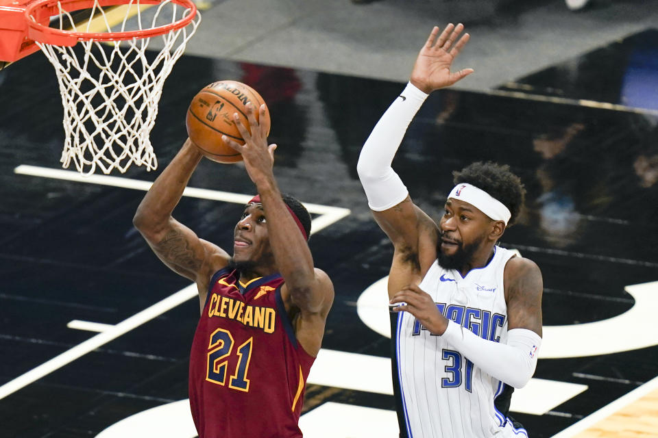 Cleveland Cavaliers guard Damyean Dotson (21) is fouled by Orlando Magic guard Terrence Ross (31) as he goes up for a shot during the second half of an NBA basketball game, Monday, Jan. 4, 2021, in Orlando, Fla. (AP Photo/John Raoux)