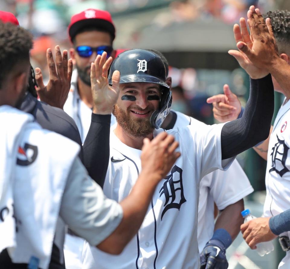Detroit Tigers catcher Eric Haase high-fives teammates after scoring during the second inning against the Chicago White Sox at Comerica Park in Detroit, Sunday, July 4, 2021.