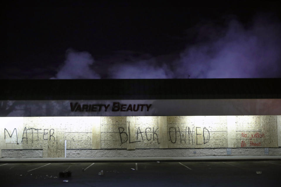 A business labeled "Black Owned" remains untouched by looters, Friday, May 29, 2020, in Minneapolis. Protests continued following the death of George Floyd, who died after being restrained by Minneapolis police officers on Memorial Day. (AP Photo/John Minchillo)