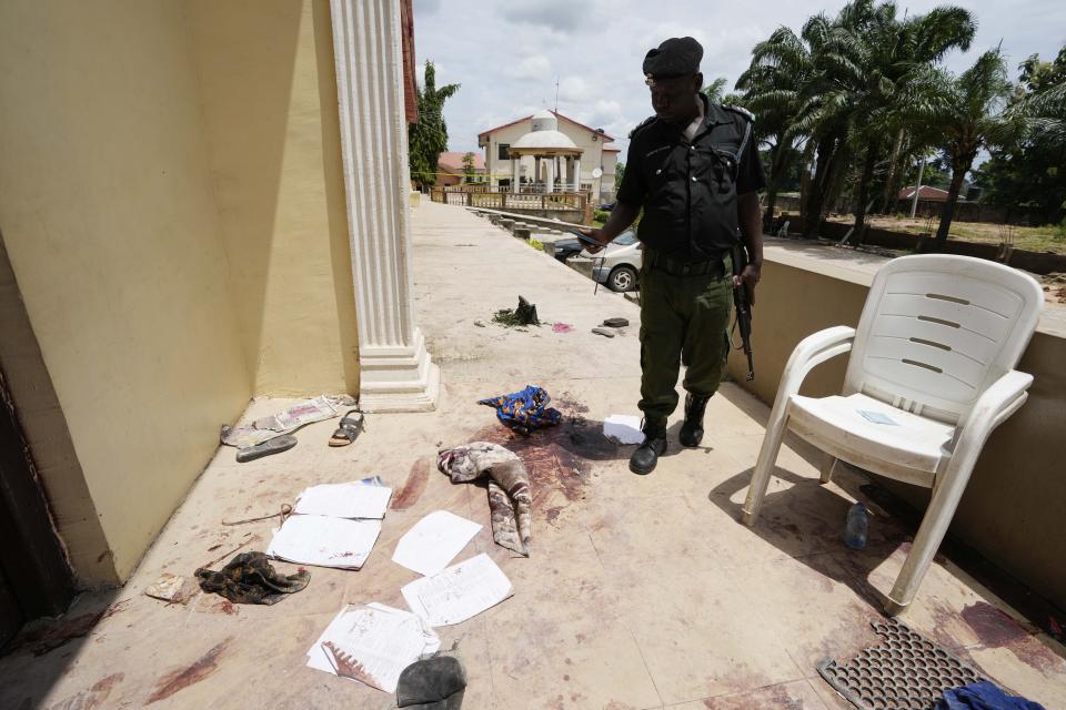 A police officer stands guard outside of the St. Francis Catholic church in the town of Owo, Nigeria, Monday, June 6, 2022. The gunmen who killed 50 people at a Catholic church in southwestern Nigeria opened fire on worshippers both inside and outside the building in a coordinated attack before escaping the scene, authorities and witnesses said Monday. (AP Photo/Sunday Alamba)