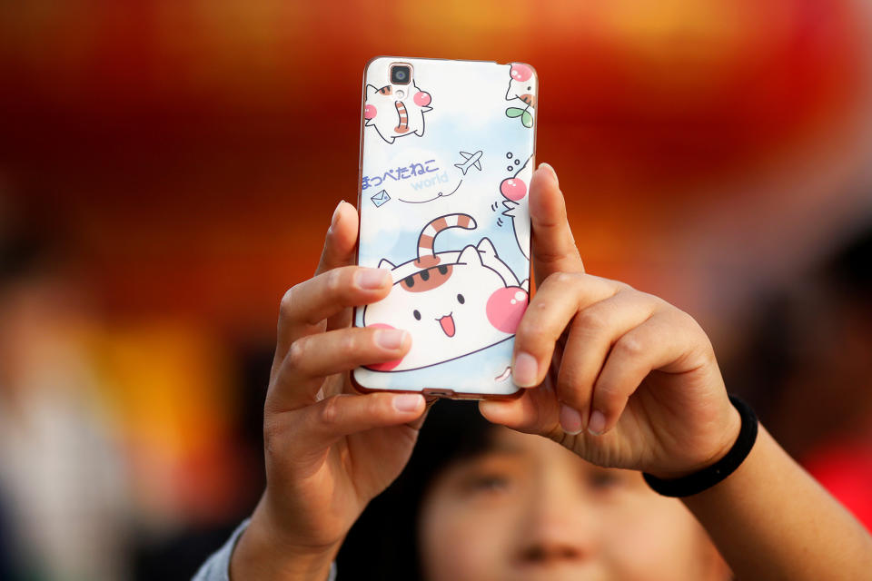 <p>A woman takes pictures of herself as people gather in Tiananmen Square to celebrate National Day marking the 67th anniversary of the founding of the People’s Republic of China, in Beijing October 1, 2016. (REUTERS/Damir Sagolj) </p>