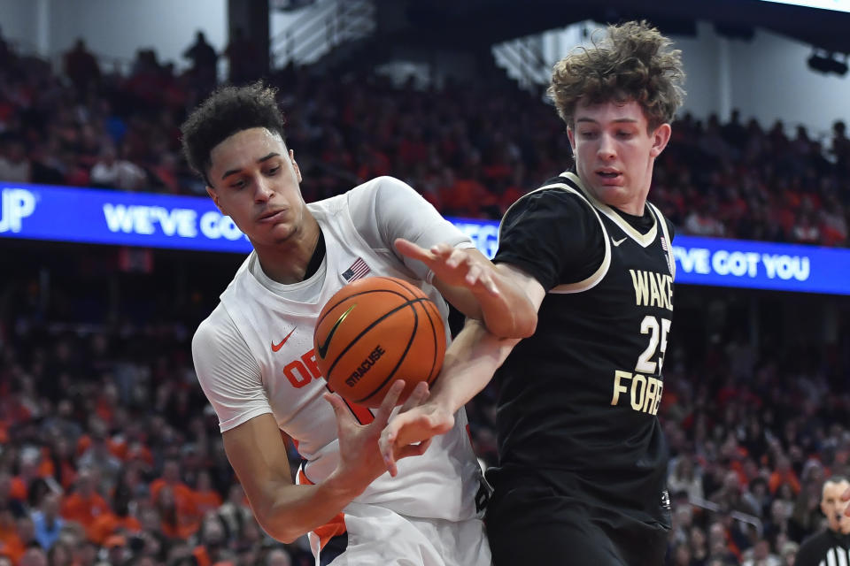 FILE - Syracuse center Jesse Edwards, left, fights for a rebound against Wake Forest forward Zach Keller during the second half of an NCAA college basketball game in Syracuse, N.Y., March 4, 2023. Edwards transferred to West Virginia for the 2023-24 season. (AP Photo/Adrian Kraus, File)
