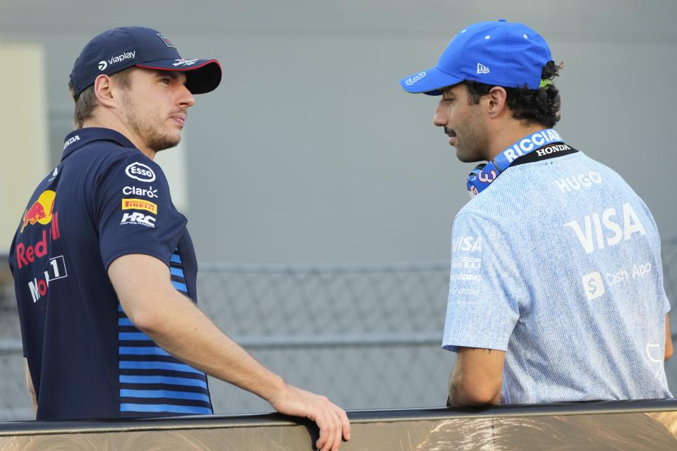 Red Bull driver Max Verstappen, left, of the Netherlands and RB driver Daniel Ricciardo of Australia talk during the drivers parade ahead of the Singapore Formula One Grand Prix at the Marina Bay Street Circuit, in Singapore, Sunday, Sept. 22, 2024. (AP Photo/Vincent Thian)