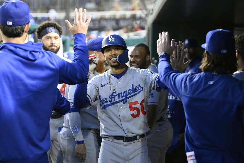 Los Angeles Dodgers' Mookie Betts celebrates his home run in the dugout with his teammates during the fourth inning of a baseball game against the Washington Nationals, Tuesday, May 24, 2022, in Washington. (AP Photo/Nick Wass)