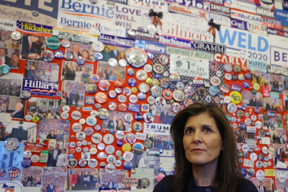 Republican presidential candidate Nikki Haley stands in front of a display of campaign memorabilia.