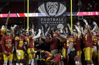 FILE - Southern California players and coaches celebrate after defeating Stanford 31-28 in the Pac-12 Conference championship NCAA college football game in Santa Clara, Calif., Friday, Dec. 1, 2017. Colorado becomes the third school to leave the Pac-12 in the last year, joining UCLA and USC, which are joining the Big Ten next year. (AP Photo/Marcio Jose Sanchez, File)