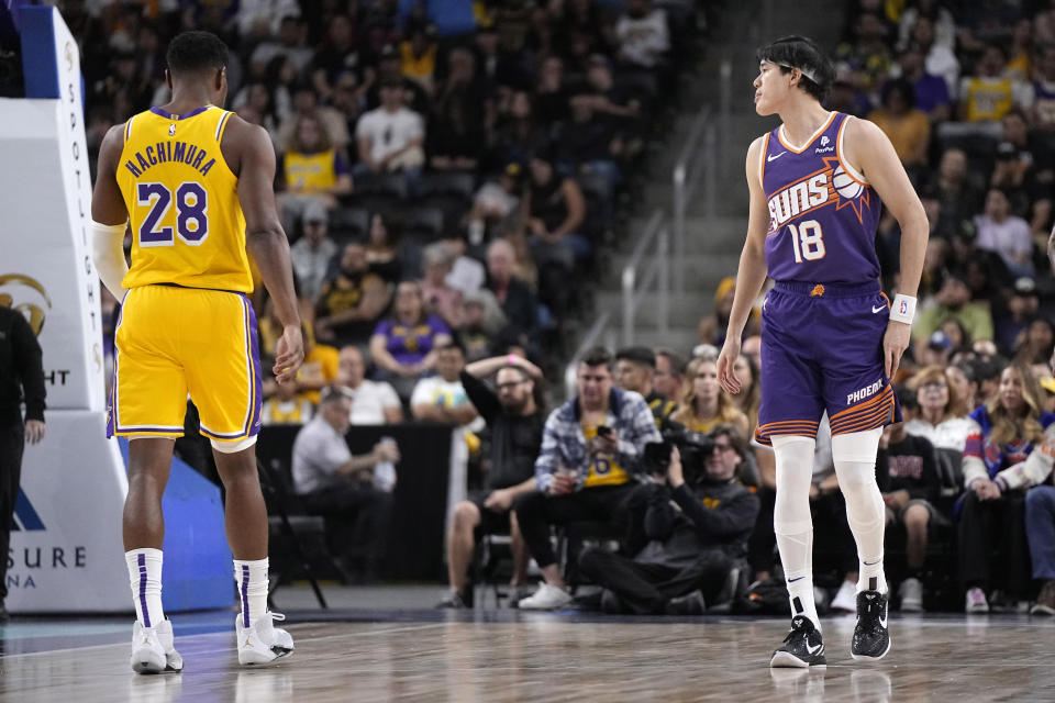 Los Angeles Lakers forward Rui Hachimura, left, stands on the court with Phoenix Suns forward Yuta Watanabe during the first half of an NBA preseason basketball game Thursday, Oct. 19, 2023, in Thousand Palms, Calif. (AP Photo/Mark J. Terrill)