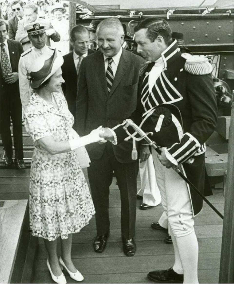 Queen Elizabeth II is welcomed aboard the USS Constitution in Boston by U.S. Navy Secretary John Middendorf, center, and Cmdr. Tyrone Martin on July 11, 1976. Prince Philip is in the background.