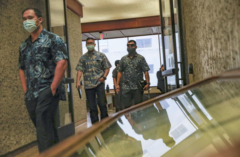 FILE - Honolulu Police Officers Zackary Ah Nee, left, Geoffrey Thom, and Christopher Fredaluces depart the district courtroom of Judge William Domingo during a preliminary hearing for the officers on Tuesday, Aug. 17, 2021, in Honolulu. Domingo on Wednesday, Aug. 18 rejected murder and attempted murder charges against the officers in the fatal shooting of a teenager, preventing the case from going to trial. (Jamm Aquino/Honolulu Star-Advertiser via AP, Pool, File)