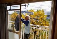 Pensioner Yoshio Koitabashi hangs his laundry at his apartment in a public housing complex in Tokyo