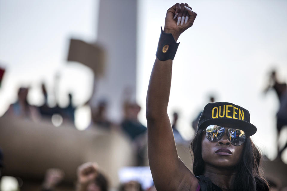 Jennifer Akabue raises her fist with other protesters as they participate in an 8-minute and 46-second kneel in honor of George Floyd during a demonstration at Dallas City Hall to denounce police brutality and systemic racism, in Dallas, June 4, 2020. The demonstration took place on the seventh consecutive day of organized protests in response to the recent deaths of George Floyd in Minneapolis and Breonna Taylor in Louisville, Ky. (Lynda M. Gonzalez/The Dallas Morning News via AP)