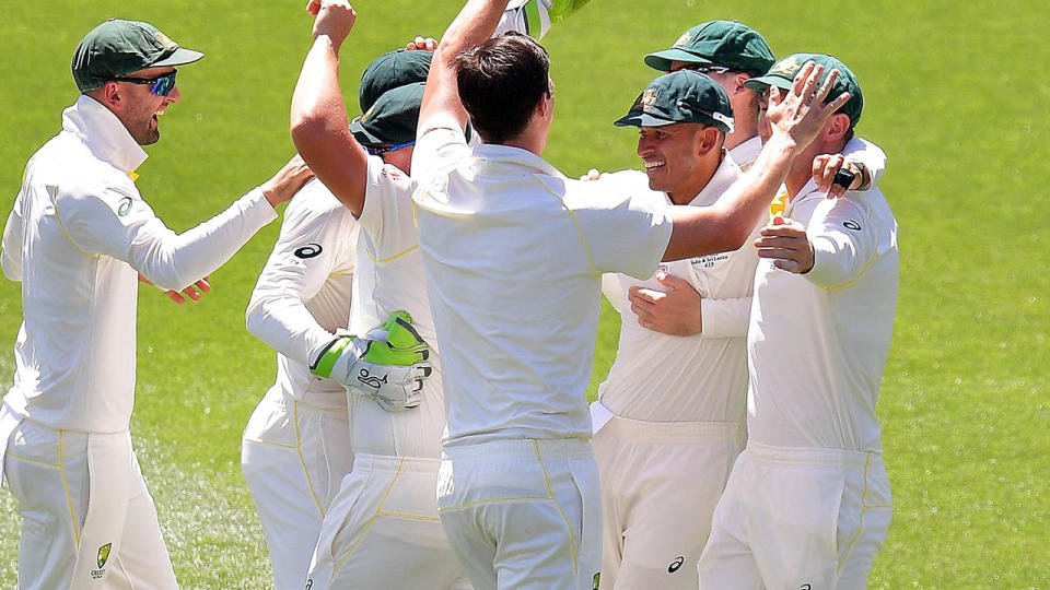 Pat Cummins celebrates with Usman Khawaja after taking a catch to dismiss Virat Kohli. (Photo by Daniel Kalisz – CA/Cricket Australia/Getty Images)