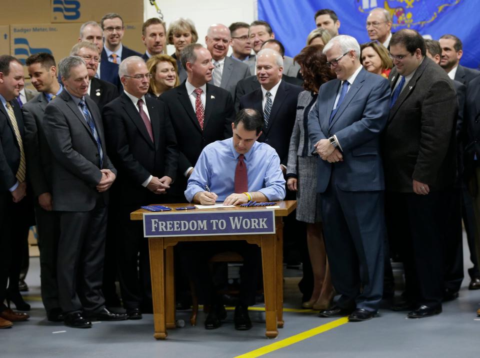 Then-Gov. Gov. Scott Walker signs a right-to-work bill into law on March 9, 2015 in Brown Deer, Wisconsin.
