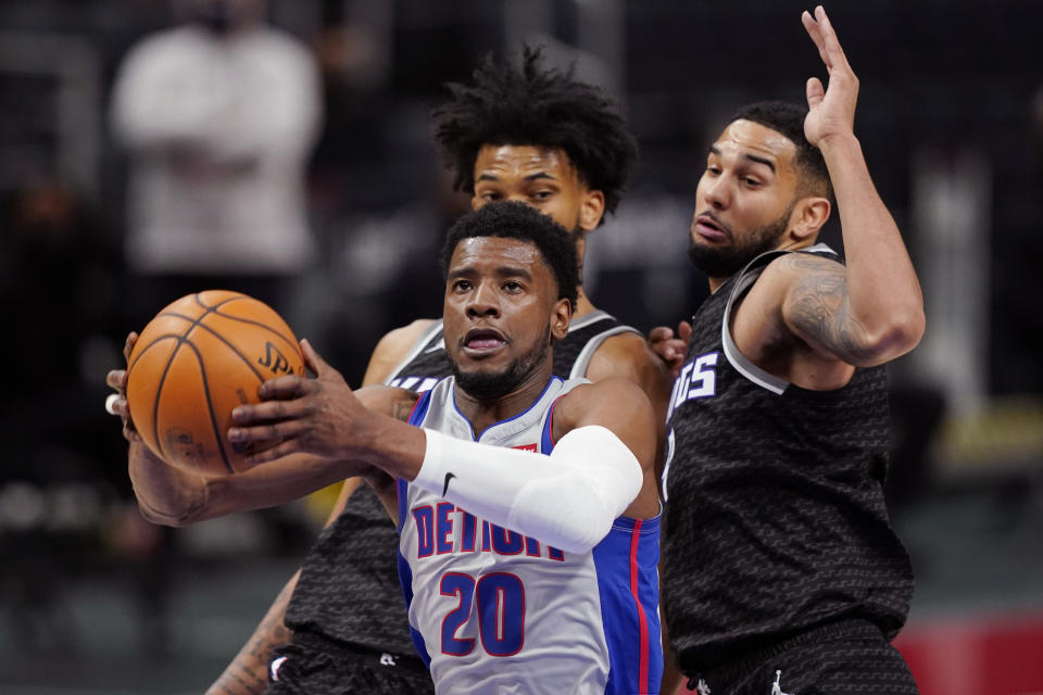 Detroit Pistons guard Josh Jackson (20) drives to the basket as Sacramento Kings forward Marvin Bagley III, left, and guard Cory Joseph defends during the second half of an NBA basketball game, Friday, Feb. 26, 2021, in Detroit. (AP Photo/Carlos Osorio)