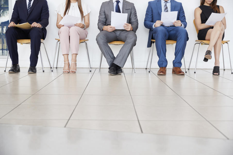 People are seen waiting holding papers.