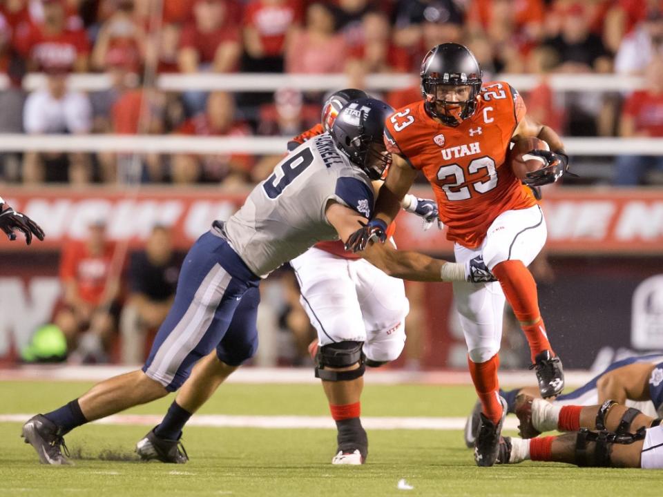 Sep 11, 2015; Salt Lake City, UT, USA; Utah Utes running back Devontae Booker (23) carries the ball as Utah State Aggies linebacker Kyler Fackrell (9) attempts to make the tackle during the first half at Rice-Eccles Stadium. Utah won 24-14. Mandatory Credit: Russ Isabella-USA TODAY Sports