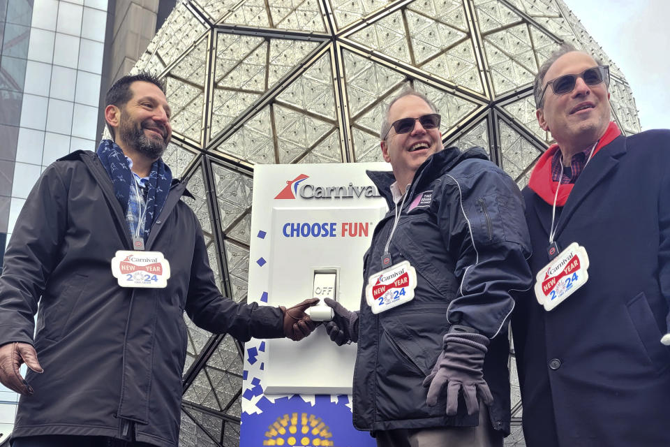 From left, Josh Weinstein, President, CEO, and Chief Climate Officer of Carnival Corporation, Tom Harris, President of the Times Square Alliance and Jeffrey Straus, President of Countdown Entertainment prepares to push the switch to test the Times Square ball on Saturday, Dec. 30, 2023, for annual New Year's Eve ball drop in New York. With throngs of revelers set to usher in the new year under the bright lights of Times Square, officials and organizers say they are prepared to welcome the crowds and ensure their safety. (AP Photo/Julie Walker)