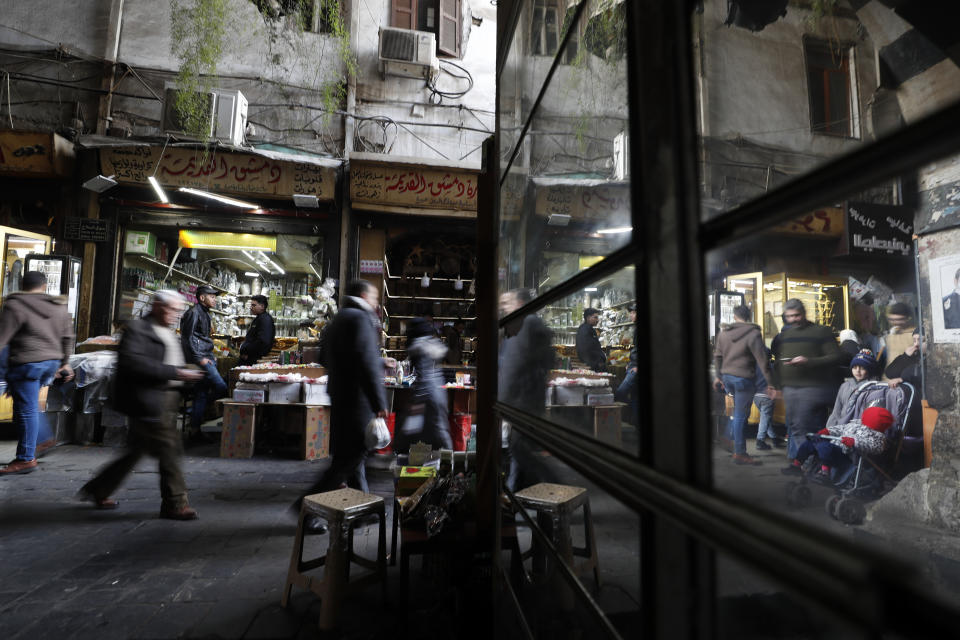 People walk through a market in Damascus, Syria, Sunday, Dec. 15, 2022. Syria's economy has hit its lowest point since the country's civil war began nearly 12 years ago, with severe fuel shortages in both government and rebel-held areas, spiraling inflation and the Syrian currency hitting an all-time low on the black market. (AP Photo/Omar Sanadiki)