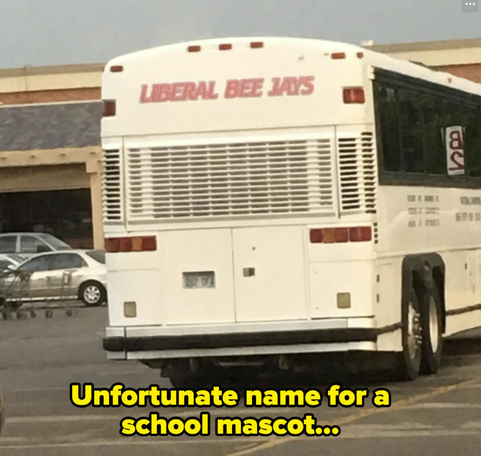 A white bus in a parking lot with the text "LIBERAL BEE JAYS" on the back